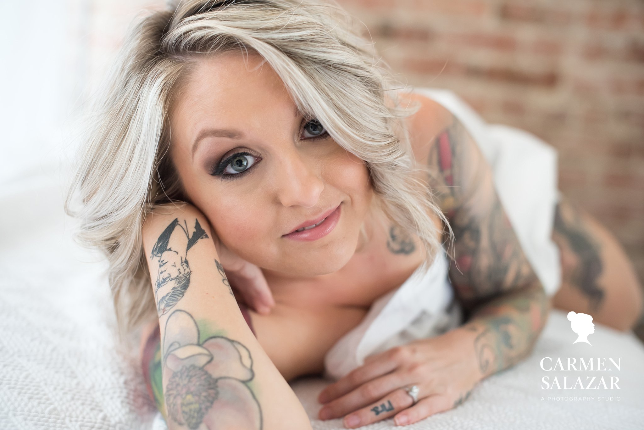Blonde between white sheets; boudoir photography by Carmen Salazar