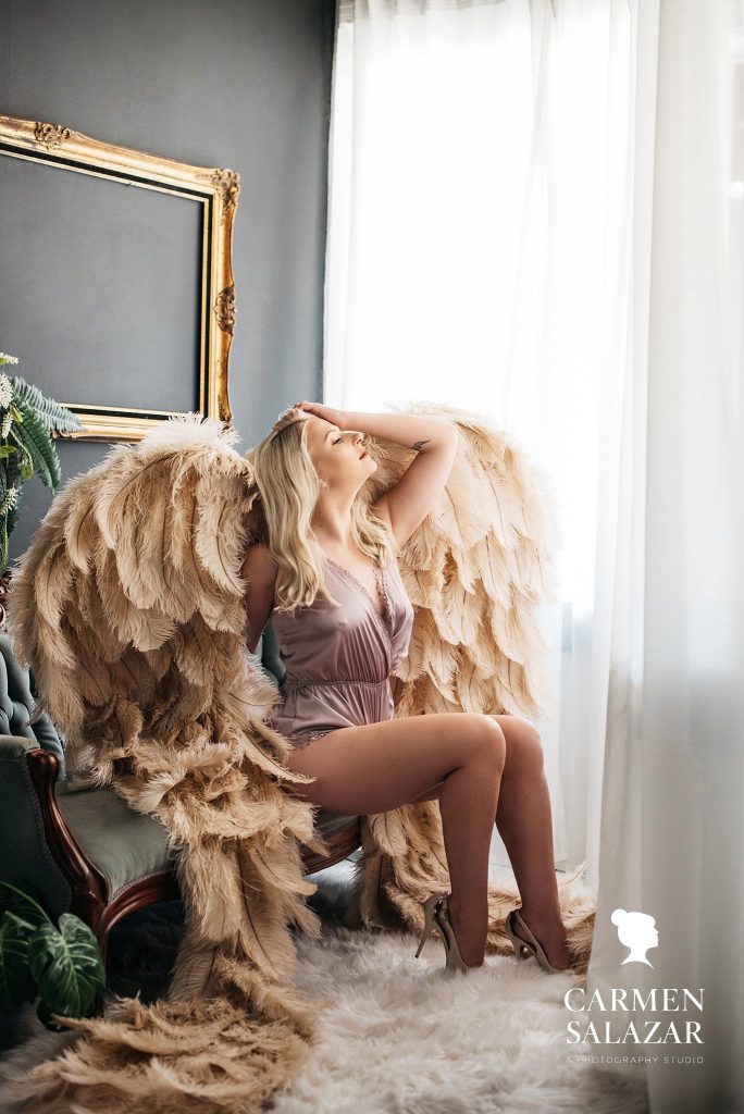 blonde model in chair with angel wings; boudoir portraits by carmen salazar