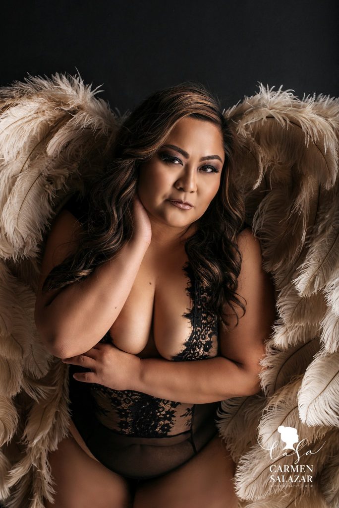 brunette in black body suit is oversized angel wings