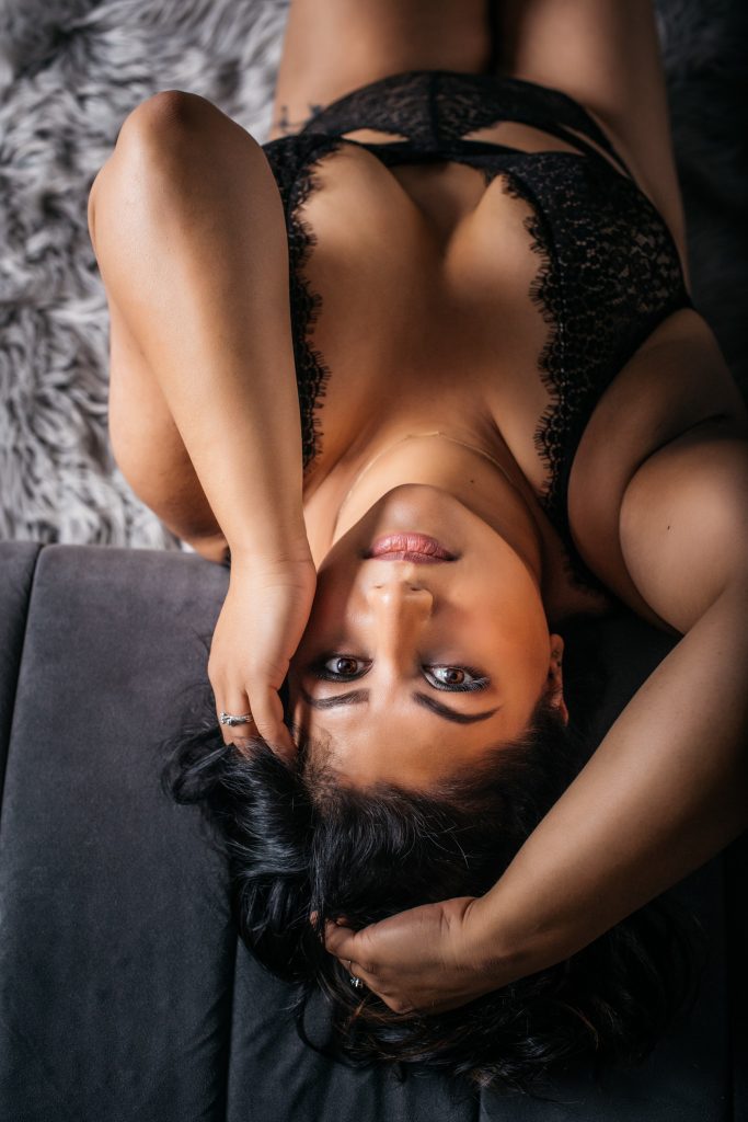 woman in black bodysuit on modern couch, boudoir photography by Carmen Salazar