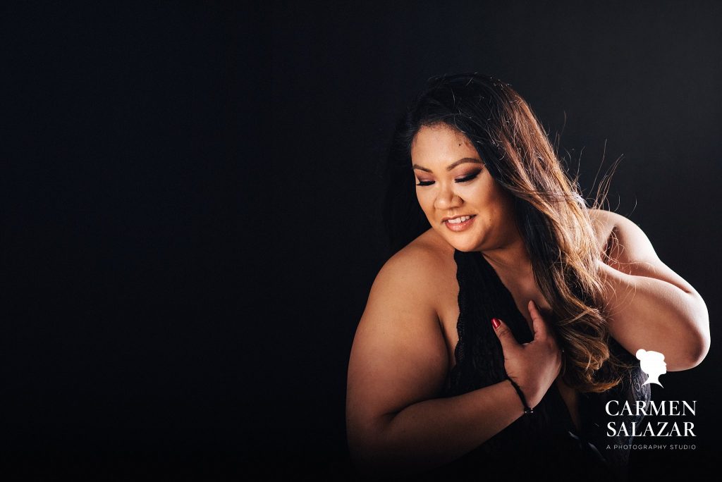 curvy woman in black teddy during boudoir photography session by Carmen Salazar