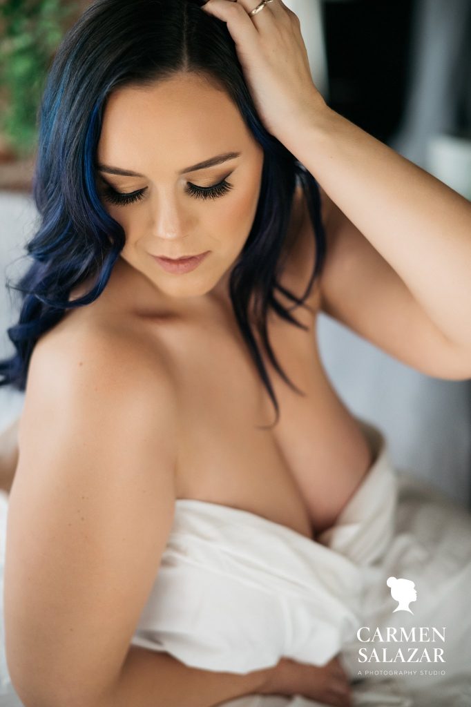 boudoir poses for curvy gals, woman in white bedsheets; boudoir photography by Carmen Salazar