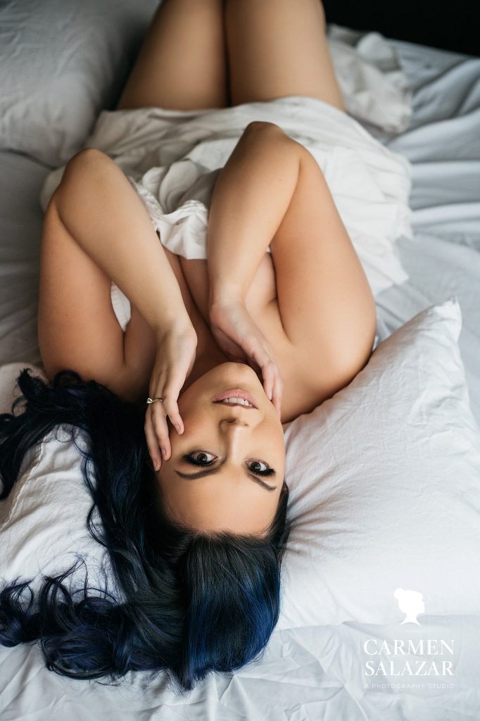 boudoir poses for curvy gals, woman in white bedsheets; boudoir photography by Carmen Salazar