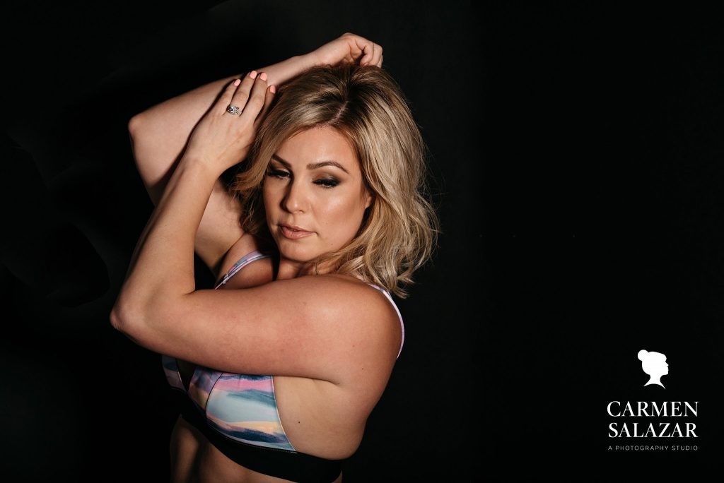 Woman in casual print sports bra with dark background; boudoir photography by Carmen Salazar