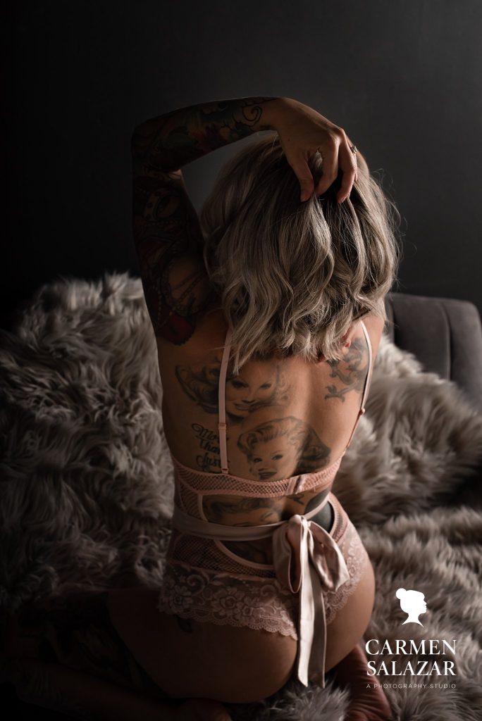 woman in peach lingerie showing off tattoos through boudoir photography, by Carmen Salazar