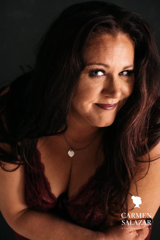 Show off your personality through boudoir photography; woman in v-neck red shirt and necklace; by Carmen Salazar