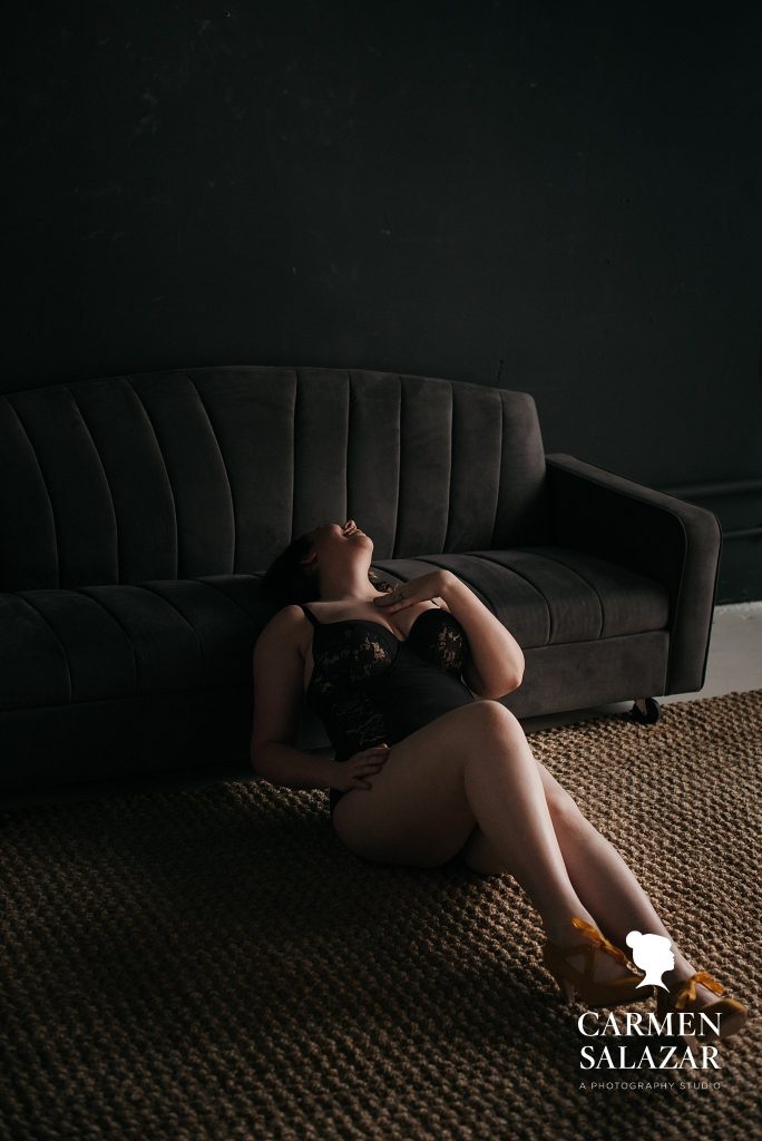 Brunette in black bodysuit against a black sofa; Brunette in black bra and black background; What if I Don’t Like How I Look In My Boudoir Photos Boudoir photography by Carmen Salazar