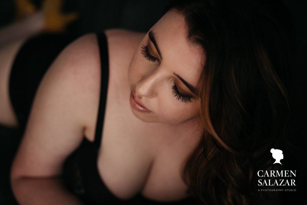 Brunette in black bra and black background; boudoir photography by Carmen Salazar