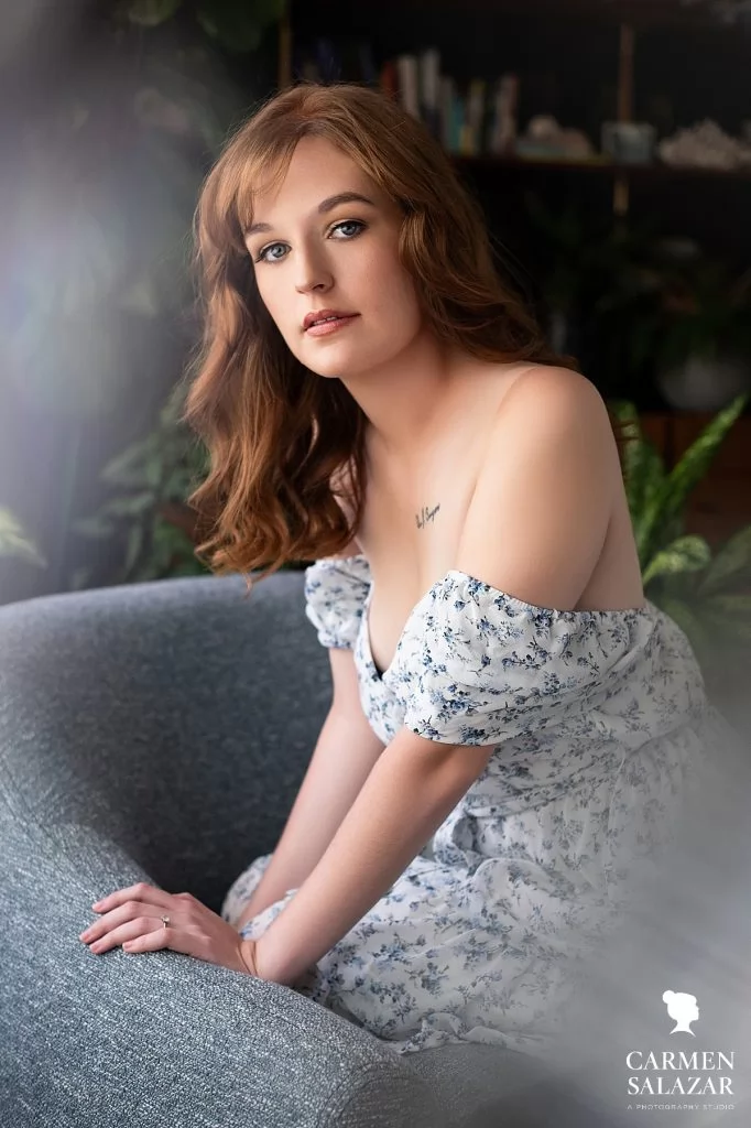 Red-head in summer blue floral dress on couch. Photography by Carmen Salazar in Sacramento.